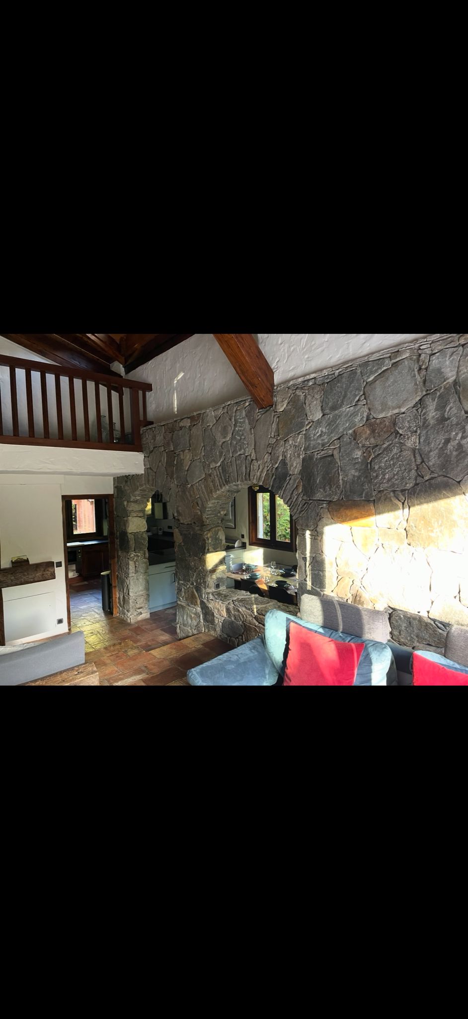 Intérieur chalet rénové – mur pierre, mezzanine bois – Canton de Vaud